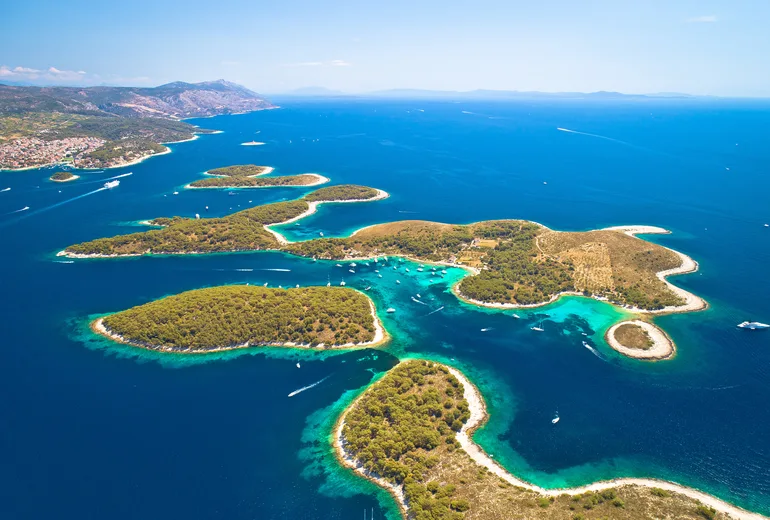 Aerial of the turquoise channels of the Pakleni islands dotted with moored yachts near Hvar