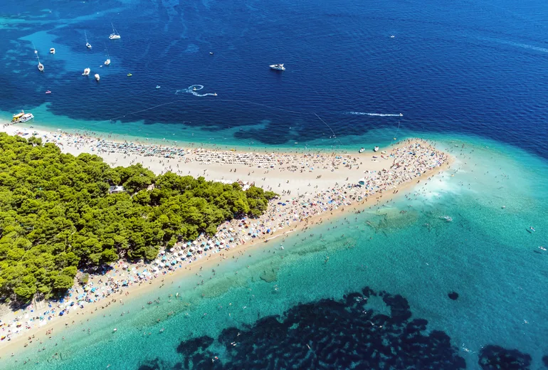 Aerial of the Zlatni Rat beach spit on Brac island reaching into turquoise sea