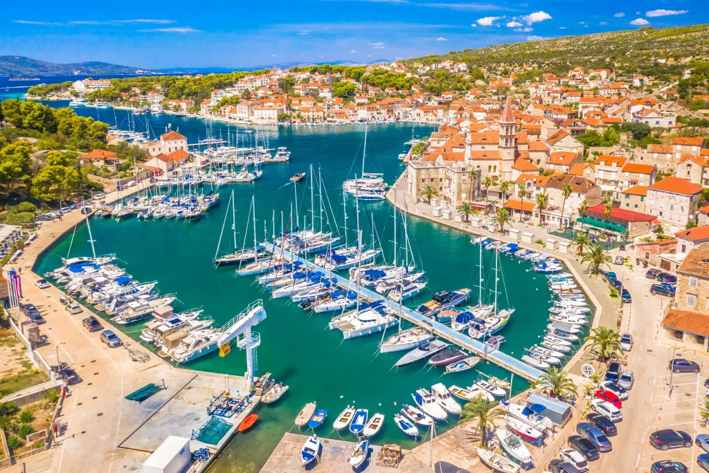 Aerial of Milna marina and stone village with church tower, Brac island