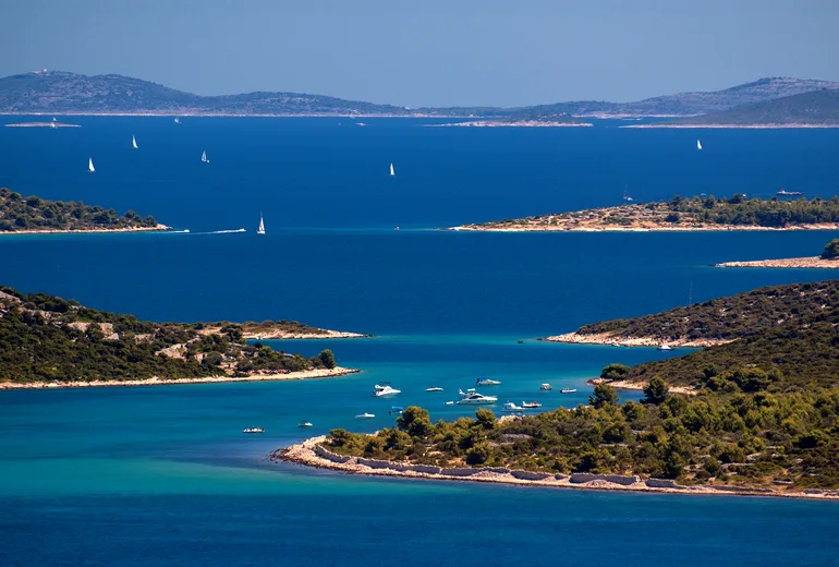 Sailboats under white sails among the Croatian islands