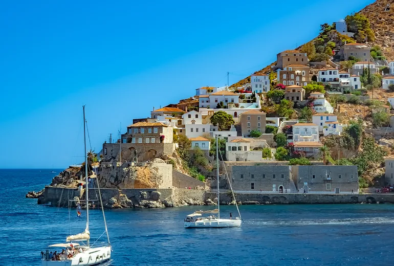 Sailing yachts entering Hydra harbour in Greece
